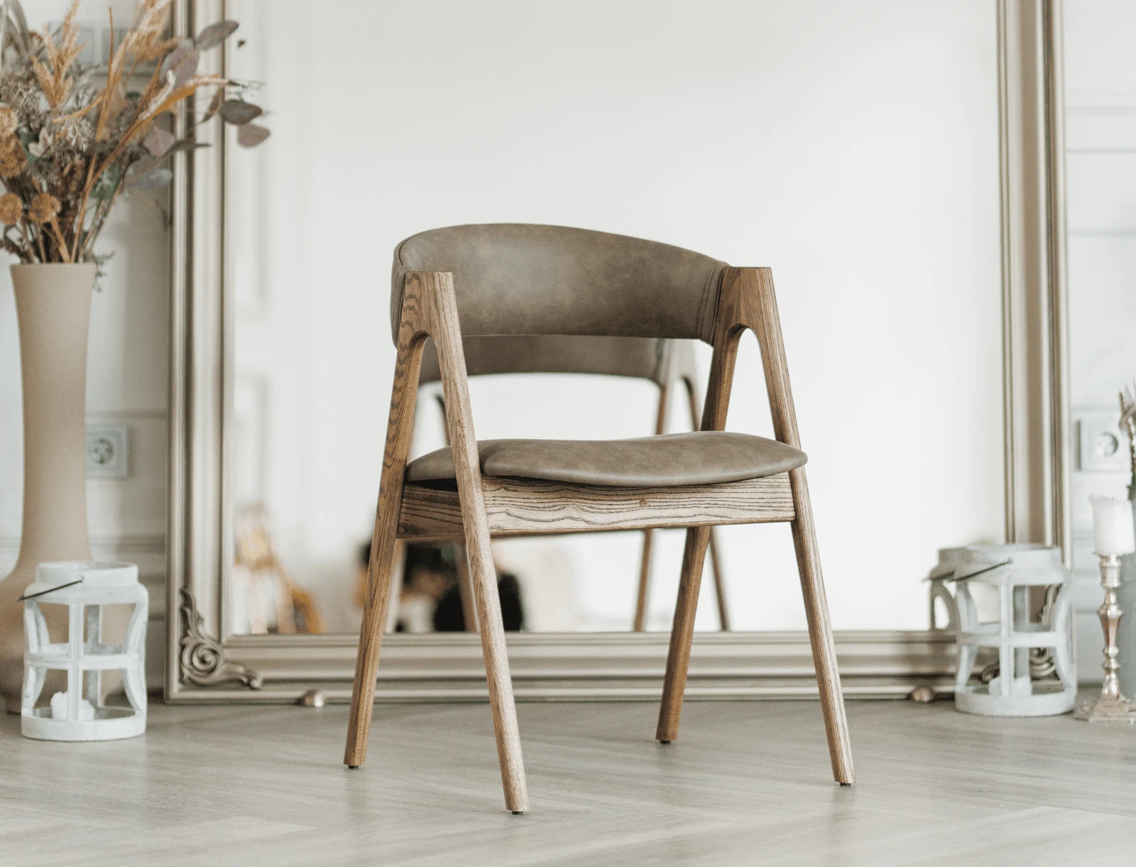 Coffee-brown Como leather Lain chair on natural-ash frame, three-quarter view in a soft-lit living room