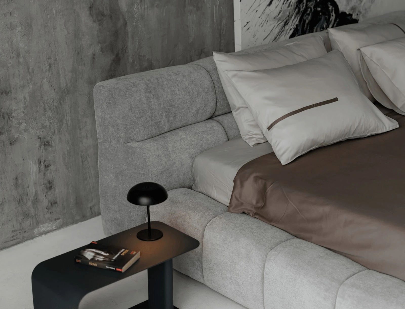 Grey velvet Nao with stacked pillows and a concrete wall behind