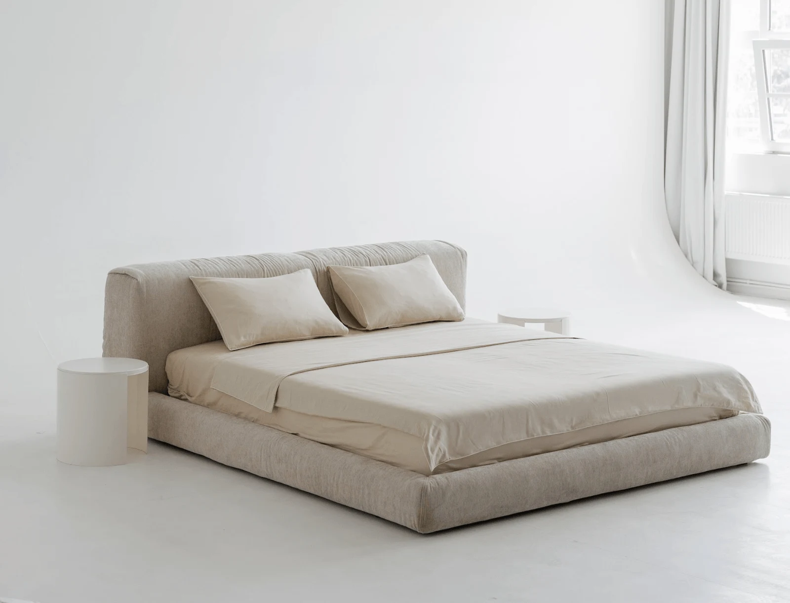 Sand Grenoble 904 Marmaris in a clean studio with a single pebble side table on the left and soft daylight falling on the headboard