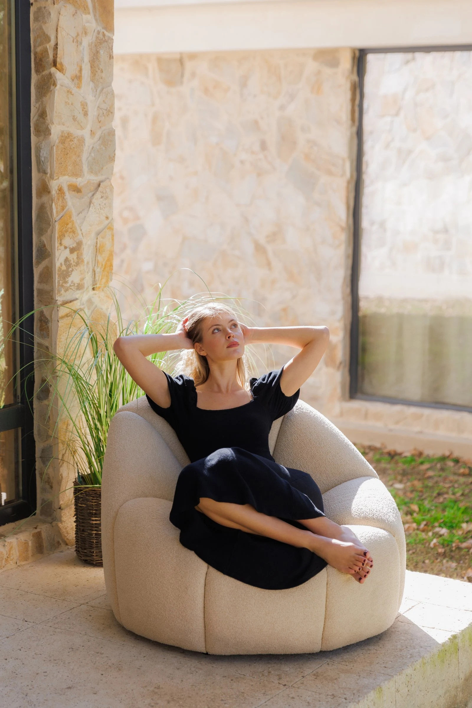 Side angle of the Flora chair on the villa patio, autumn light behind
