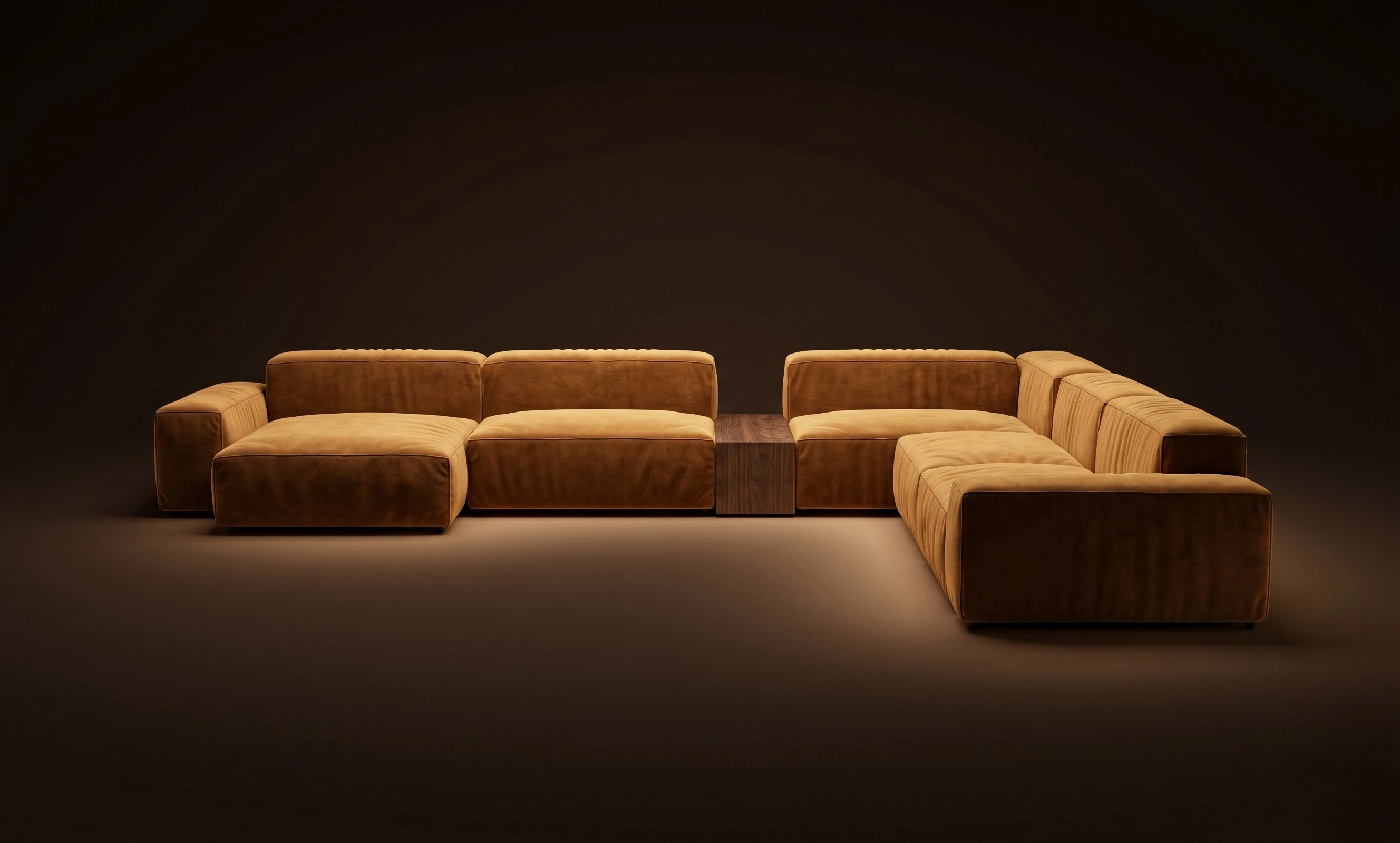 A cognac Mille U-sectional split by a wooden table island, in a dark studio