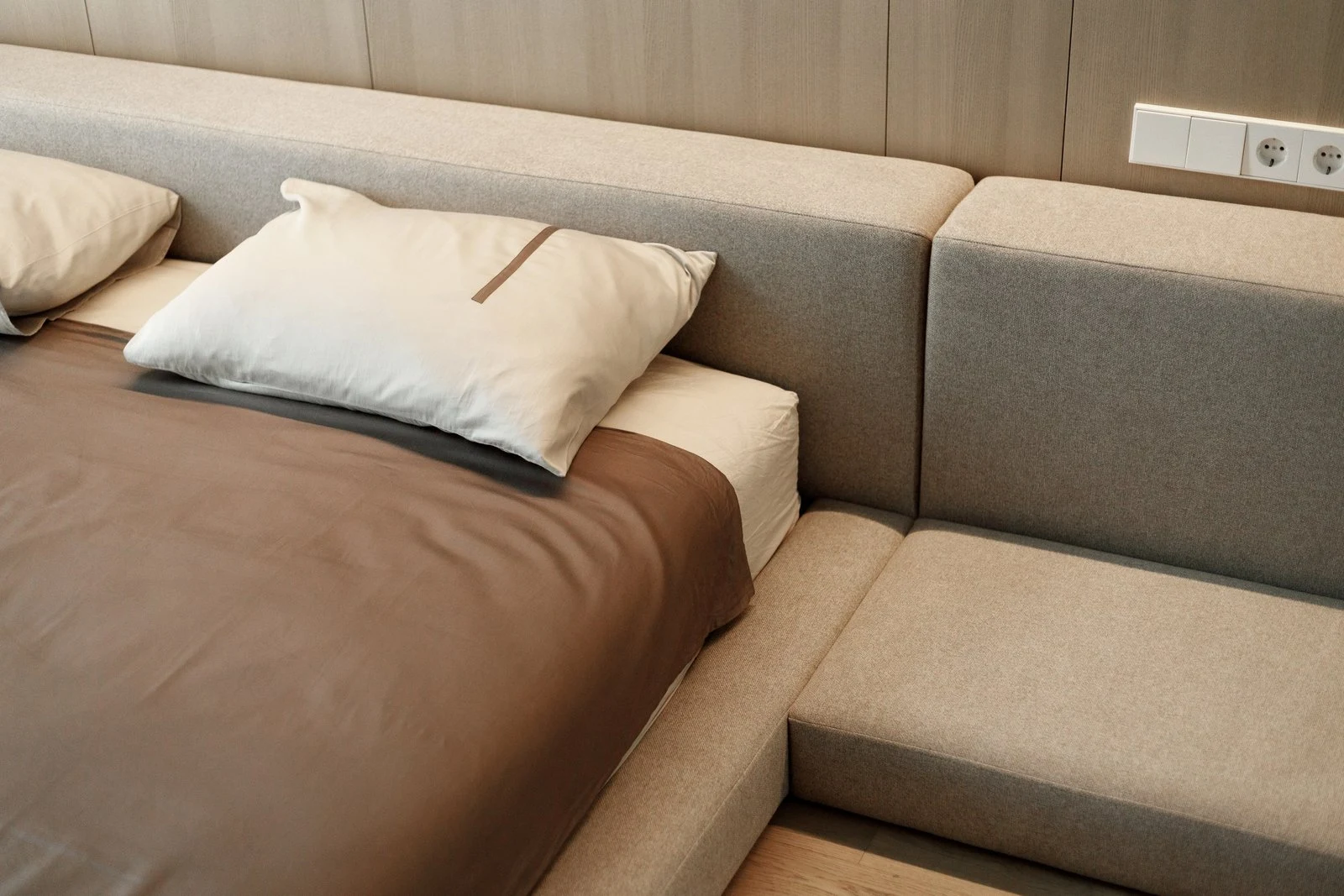 Pillows arranged in front of the Connect's back cushion modules with wood-paneled wall behind
