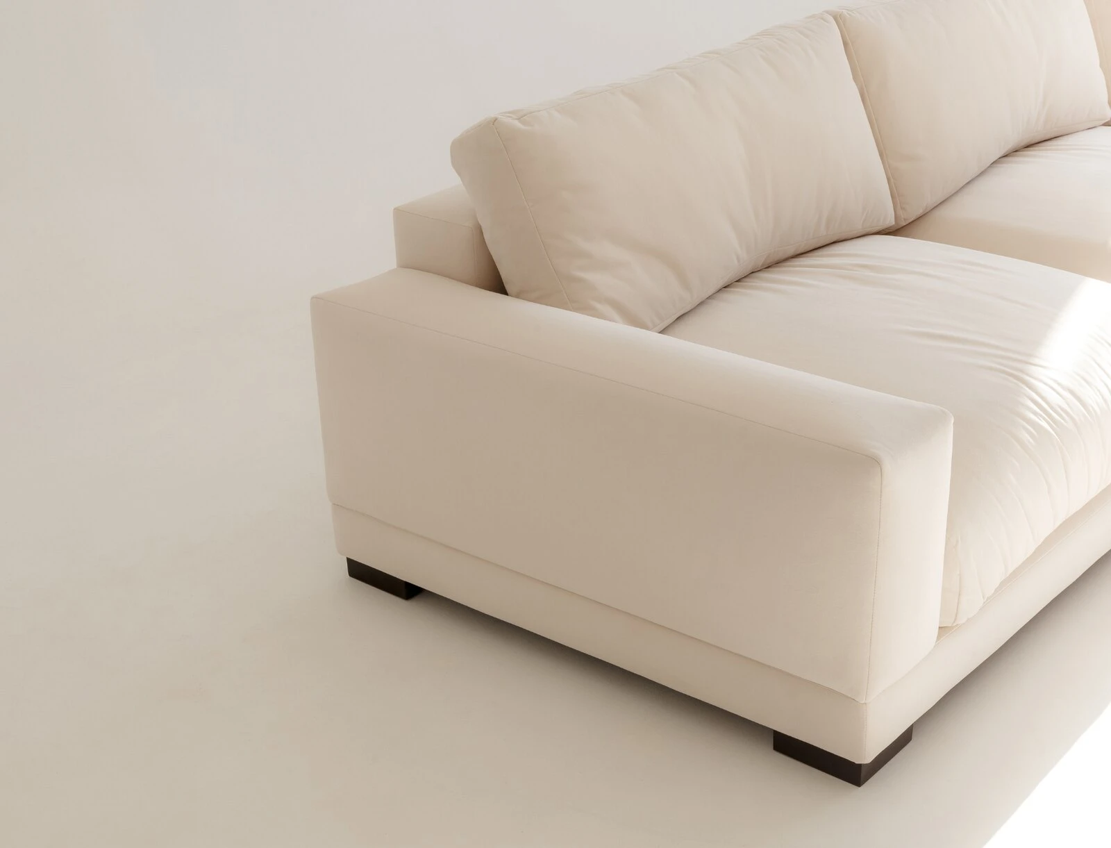 Close detail of cream Palermo armrest and dark wooden base