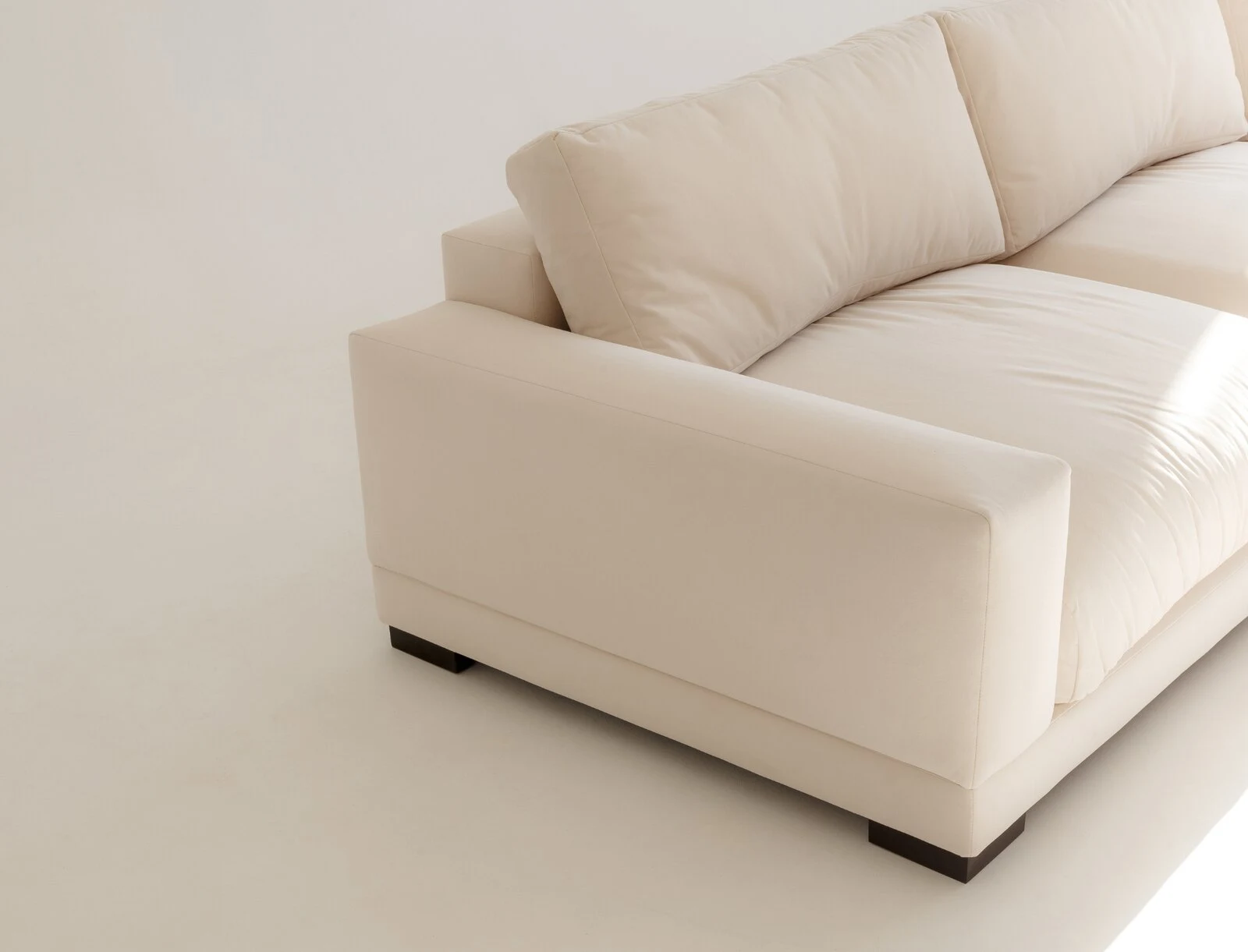 Close detail of cream Palermo armrest and dark wooden base