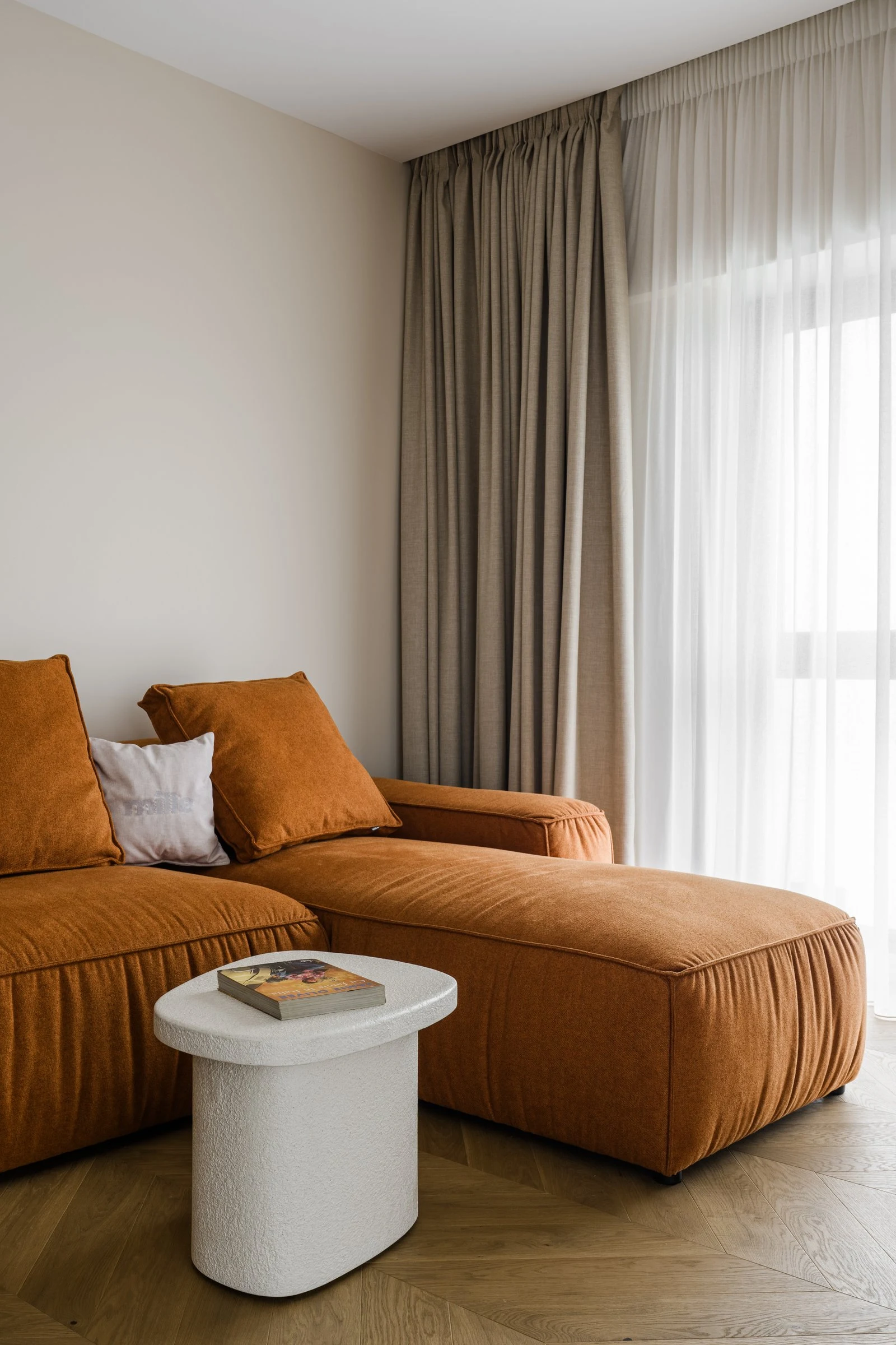 Vertical view of the cognac Milano beside a white boucle side table