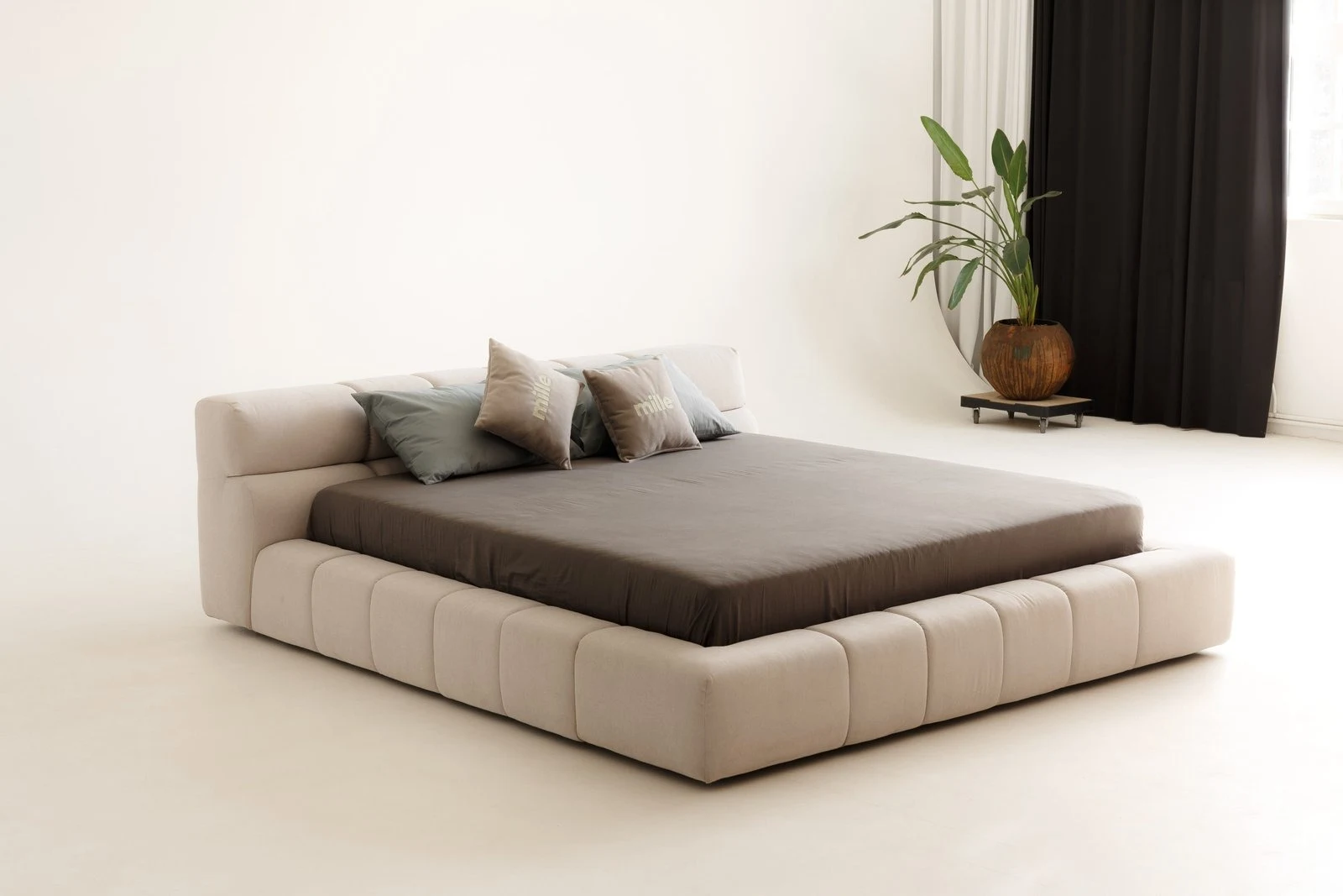 Cream Belgian velvet Nao bed in a bright minimal studio with planted curtain styling on the right