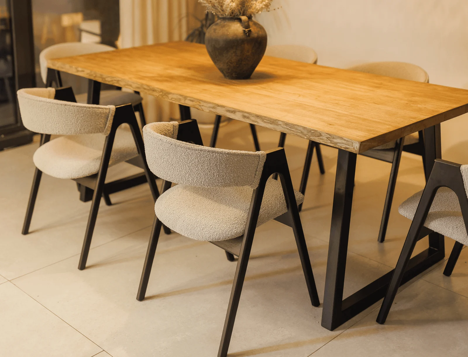Close detail of the Lain chair's side profile showing the canting ash legs meeting under the seat