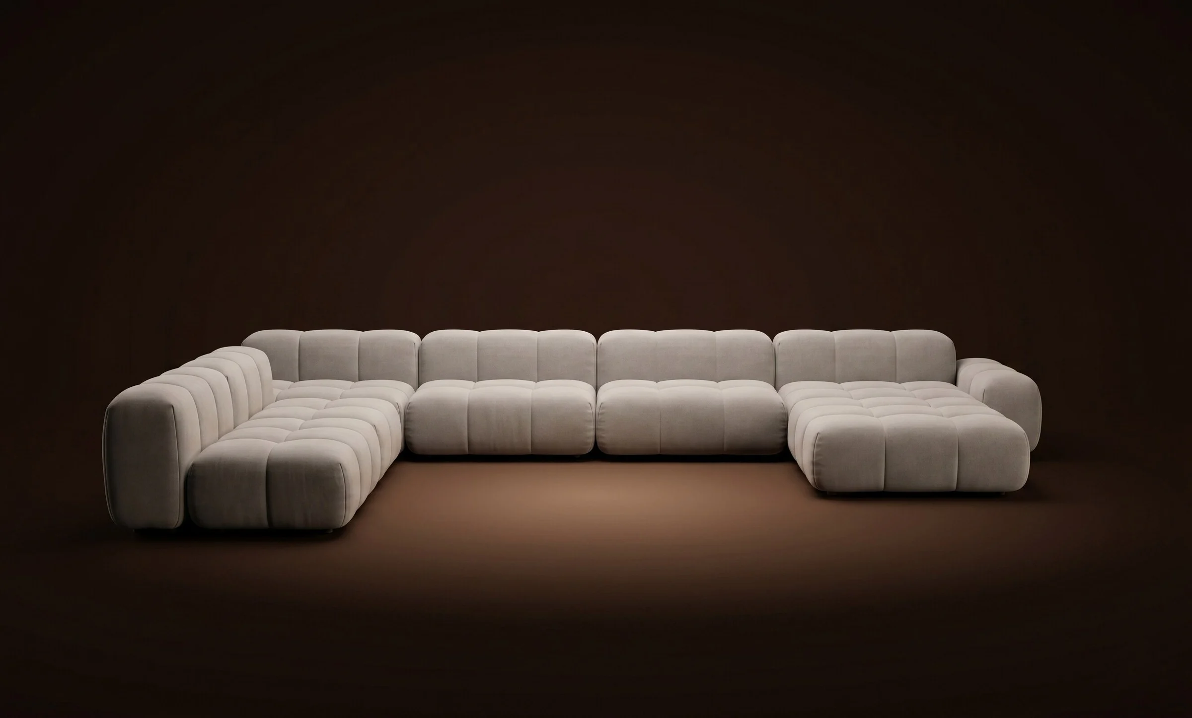 Cream Nami in a grand U-shape sectional on a dark spotlit stage
