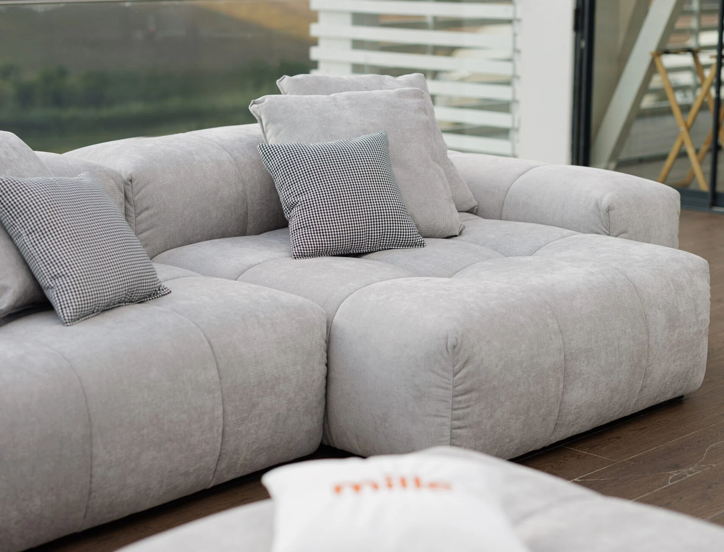 Grey Nami outdoor with a checkered accent cushion and stair view