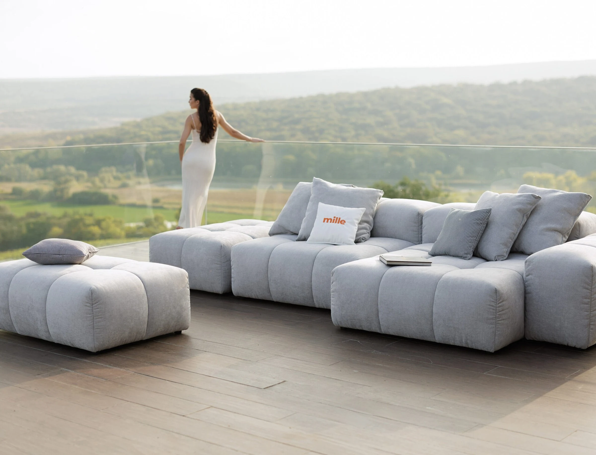 Grey Nami on a terrace overlooking countryside with a woman in a white dress