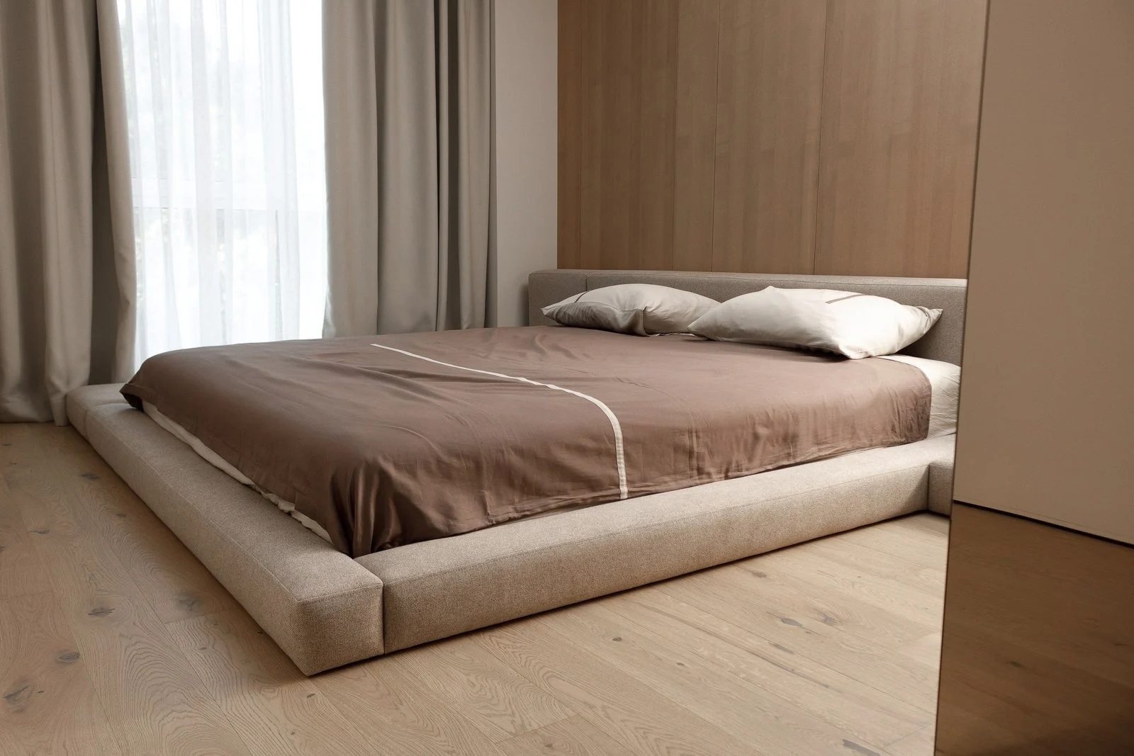 Sand Soho 902 weave Connect bed in a wood-paneled bedroom with an integrated bench extension on the right side, draped with a brown sateen duvet