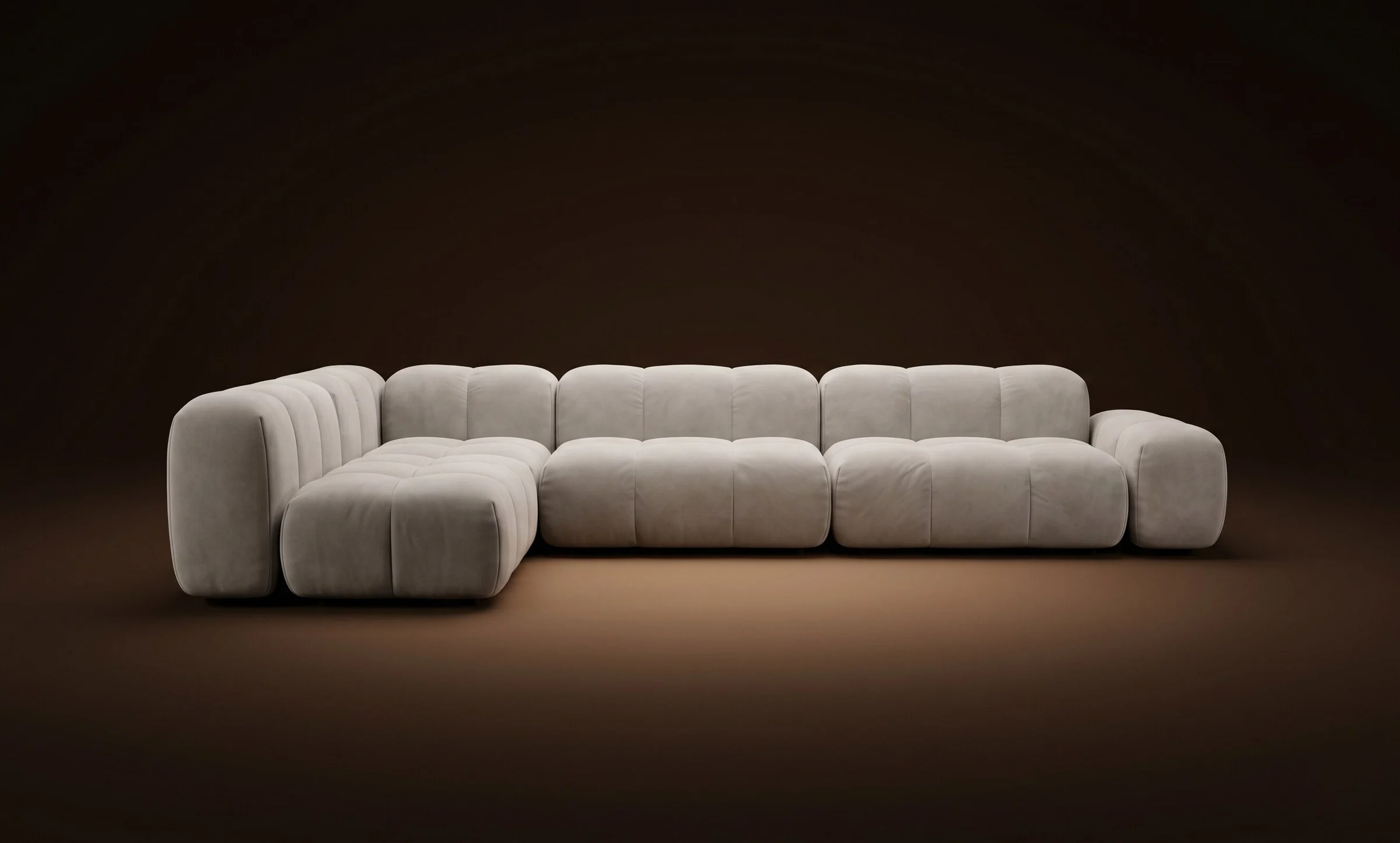 Cream Nami in a long L sectional with corner module on a dark spotlit stage