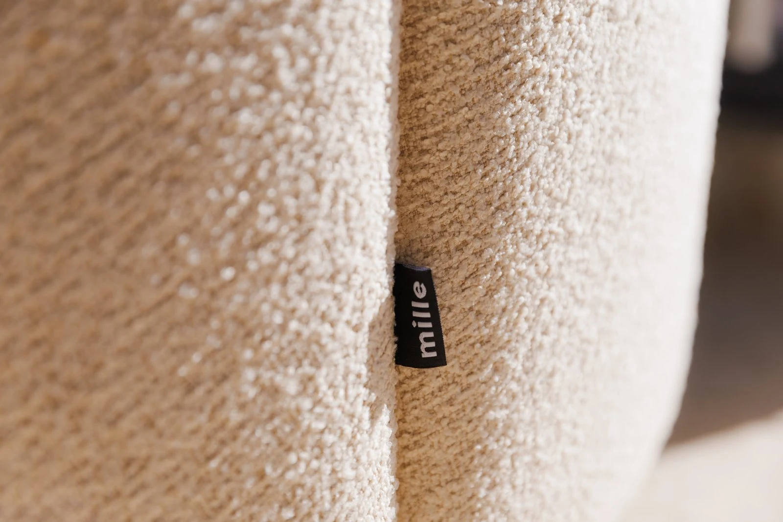 Close detail of the small Mille label sewn into the cream Everest 903 boucle Flora chair