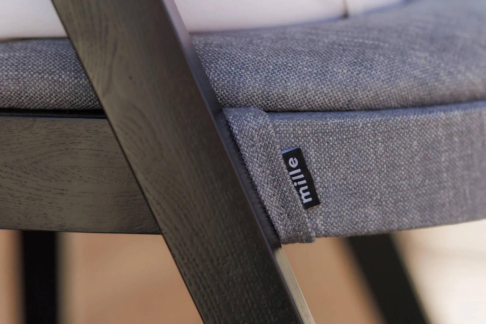 Close detail of the small Mille label sewn into the grey Antwerp 180018 seat of the Baffi bar stool