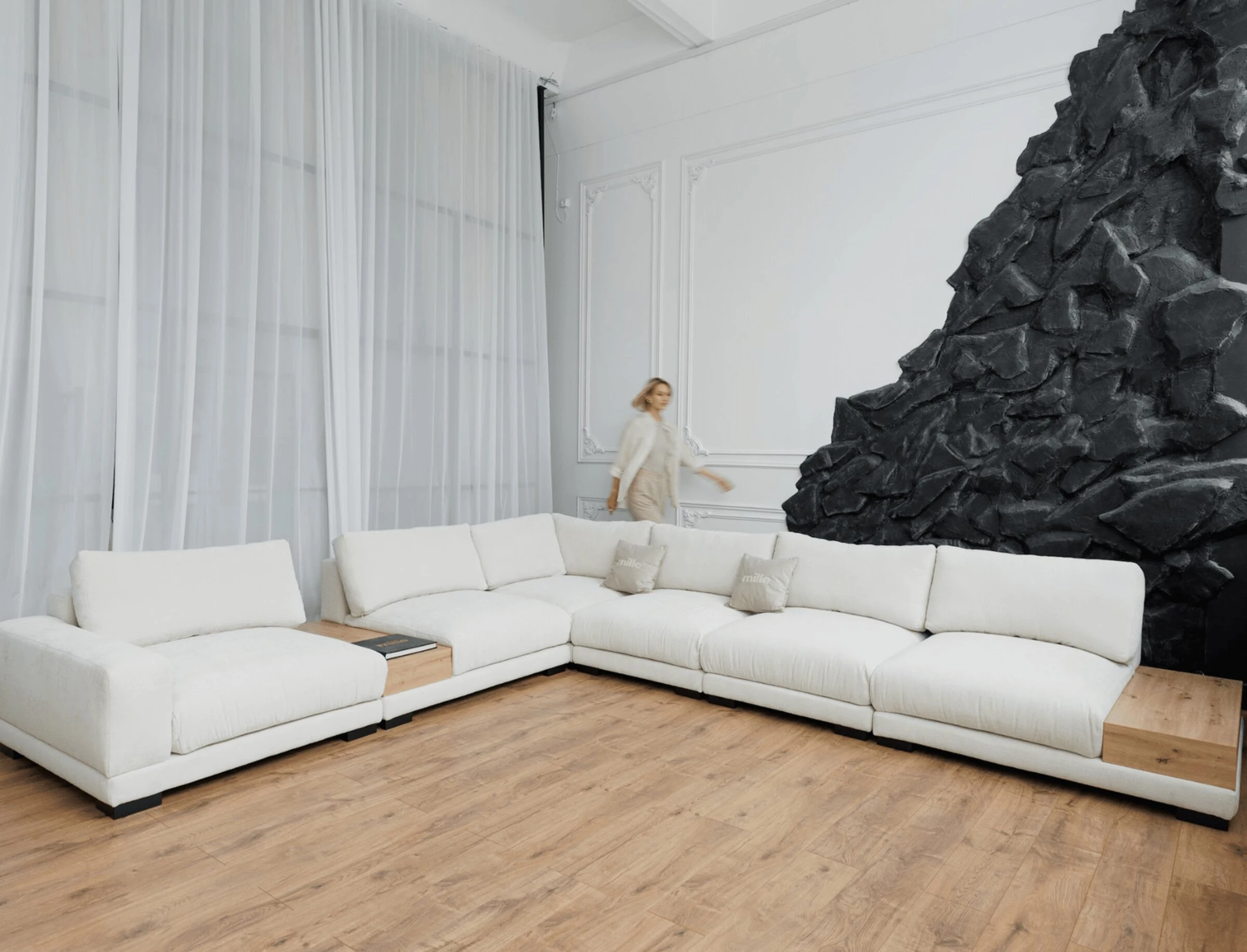 Cream Palermo L-sectional set against a textured black stone-art feature wall with sheer curtains