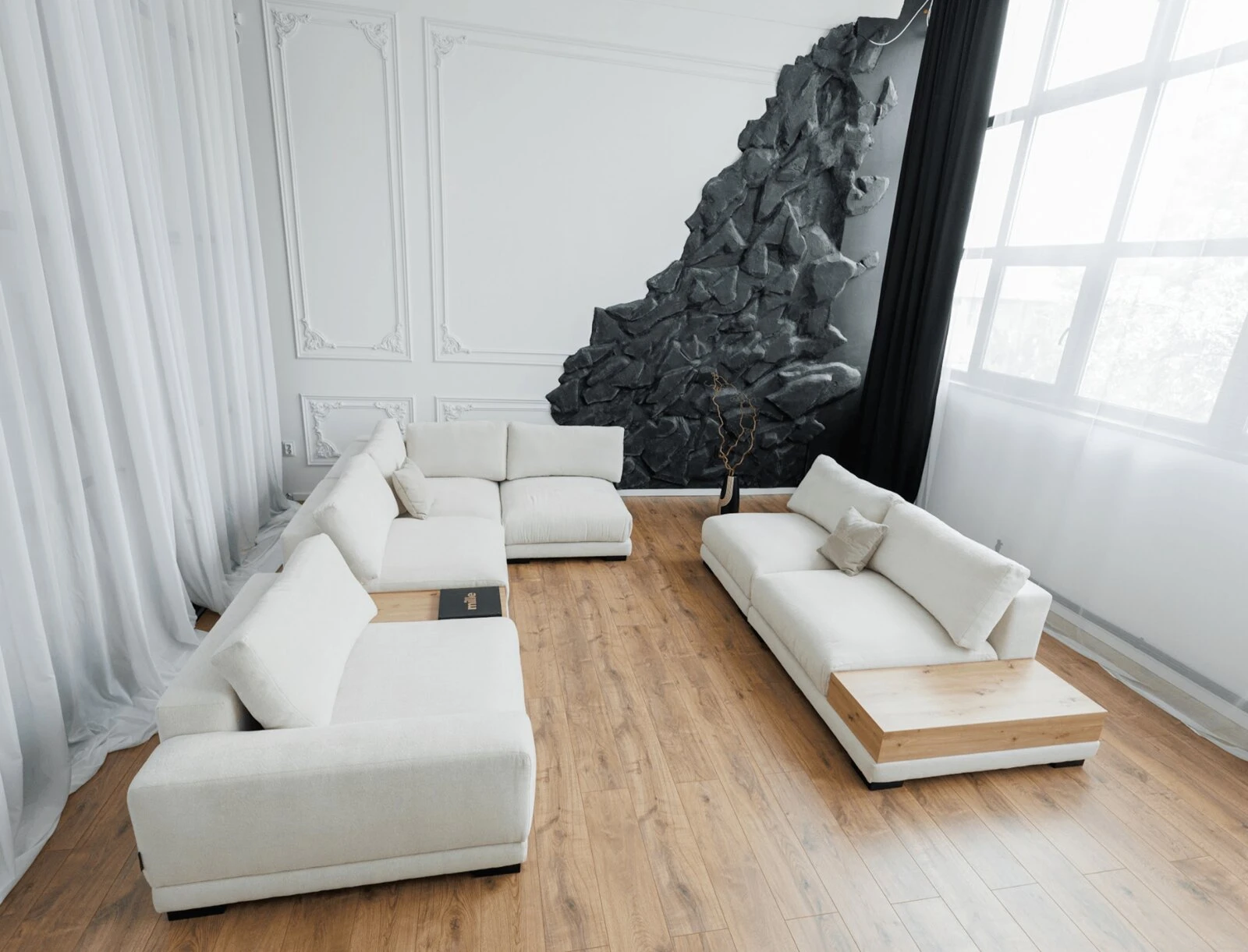 Cream Palermo L-shape against a textured stone-art wall in daylight, with sheer curtains and oak floor