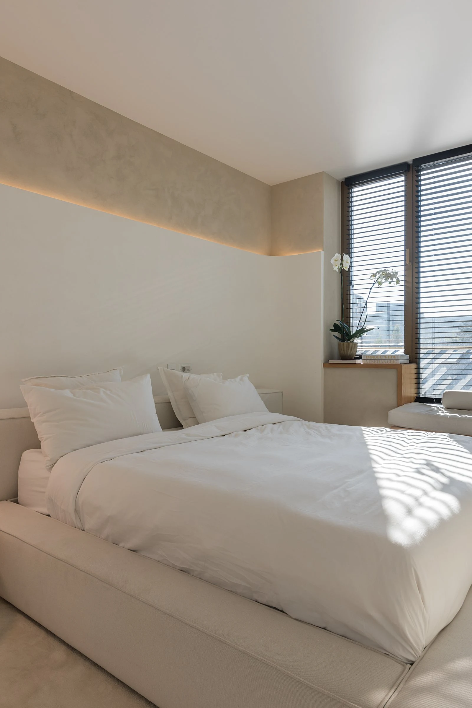 Cream-weave Palermo centered in a light bedroom with a single black pendant lamp and an orchid on a side shelf